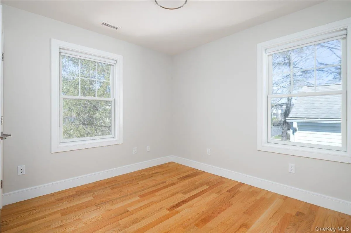 Unfurnished room with baseboards, visible vents, and light wood-style floors Unfurnished room with baseboards, visible vents, and light wood-style floors