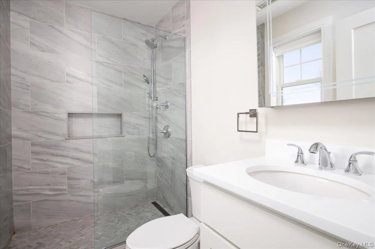 Full bath with toilet, vanity, and a walk in shower Full bath with toilet, vanity, and a walk in shower