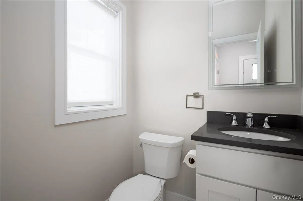 Bathroom featuring toilet and vanity Bathroom featuring toilet and vanity