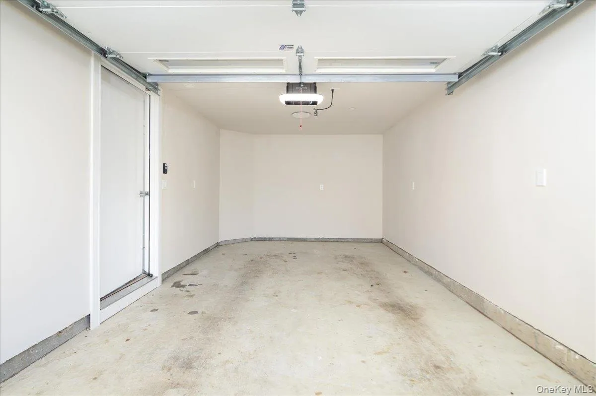 Garage with baseboards and a garage door opener Garage with baseboards and a garage door opener