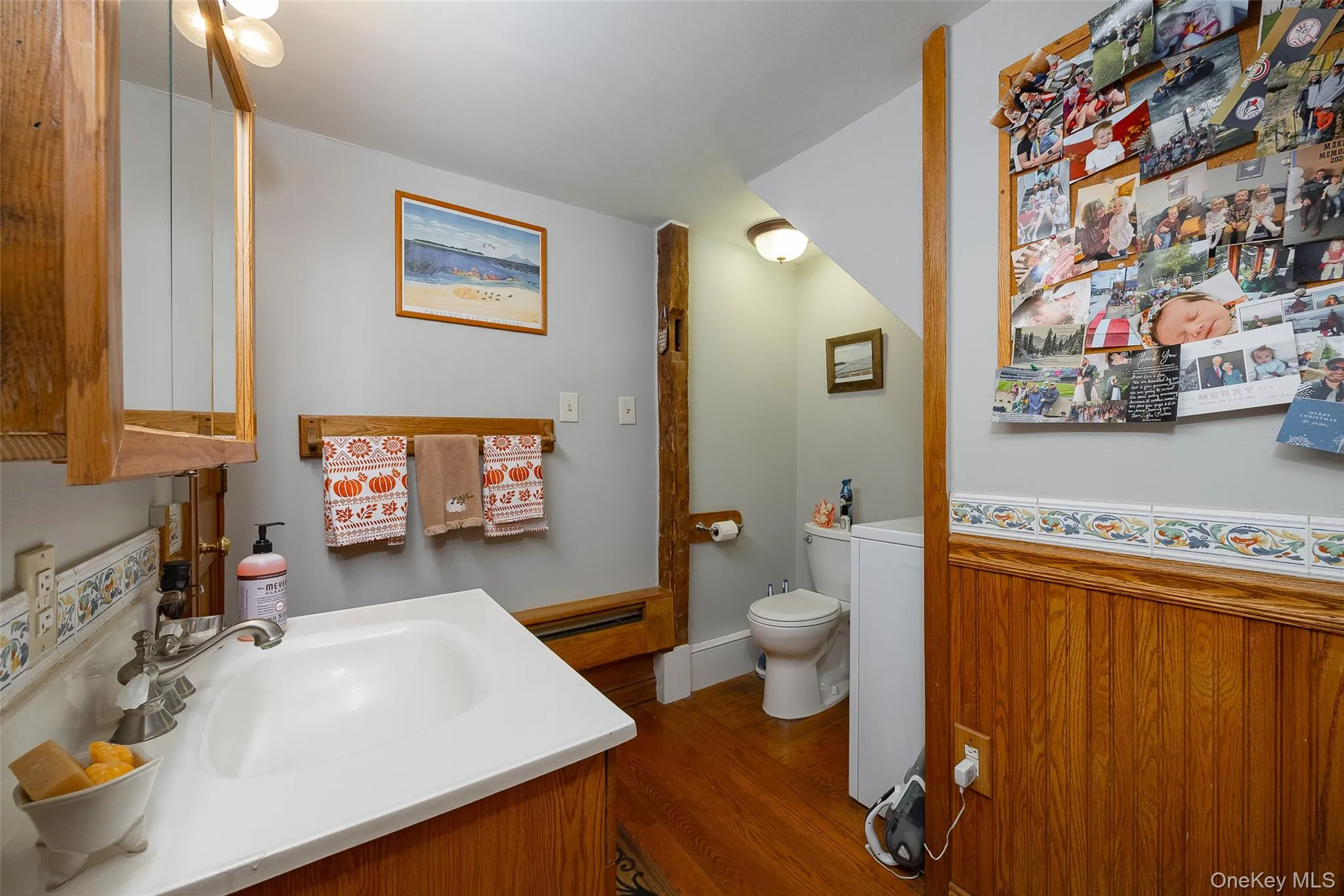 Half bathroom featuring vanity and dark wood-style floors Half bathroom featuring vanity and dark wood-style floors