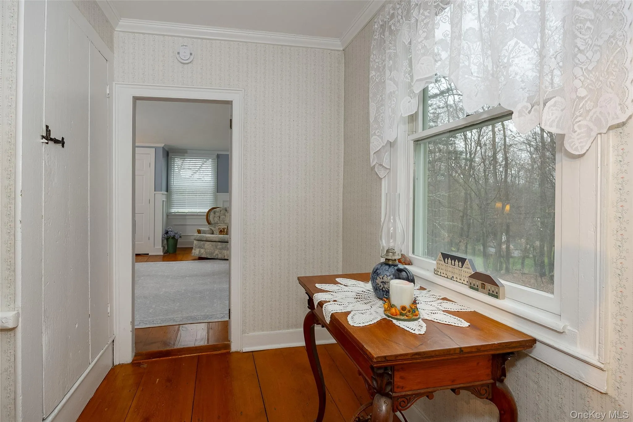 Dining area with wallpapered walls, crown molding, plenty of natural light, and hardwood / wood-style flooring Dining area with wallpapered walls, crown molding, plenty of natural light, and hardwood / wood-style flooring