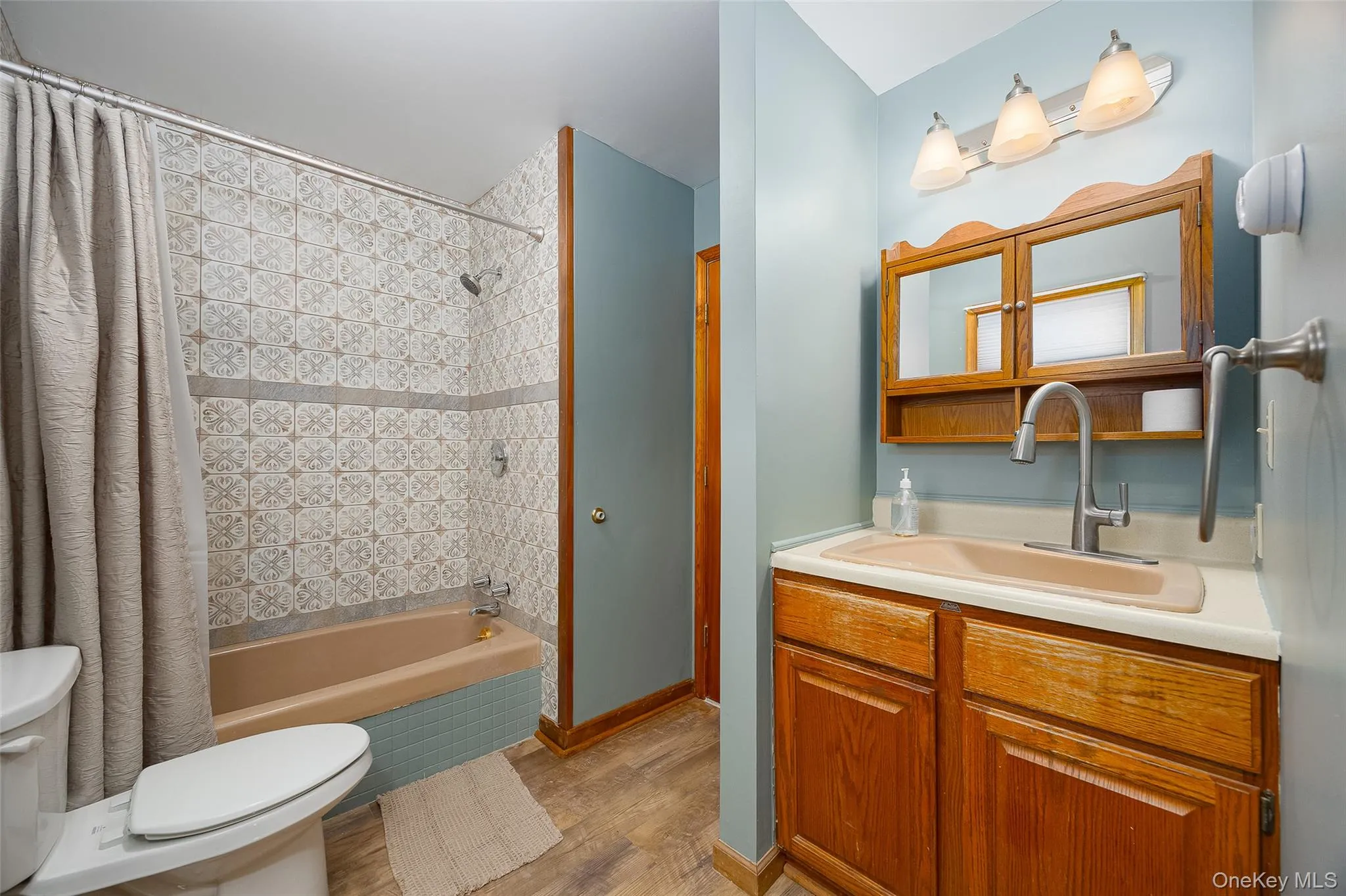 Bathroom with tiled shower / bath combo, vanity, and light wood-style flooring #2 Bathroom with tiled shower / bath combo, vanity, and light wood-style flooring #2