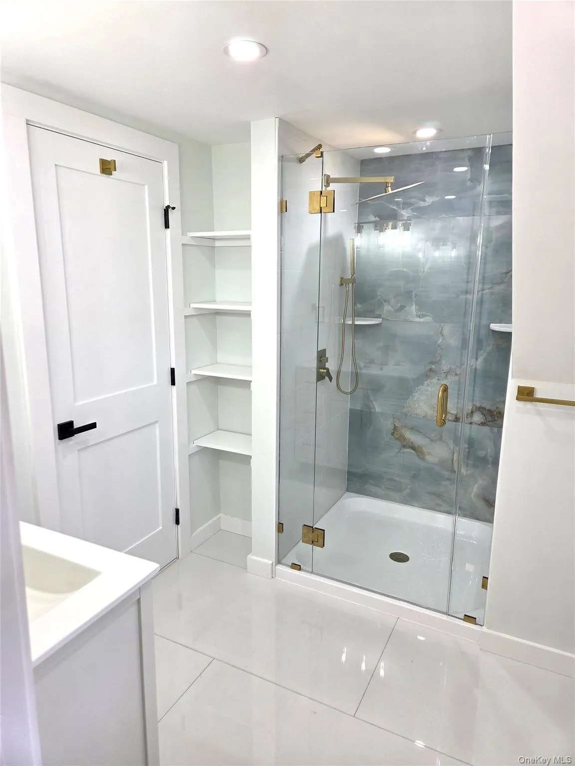 The Stunning, Completely Renovated & Elevated Primary Bathroom Offers A Custom Shower With All Porcelain Tiled Walls & Dramatic Accent Wall, Frameless Glass Doors, 48" x 24" Porcelain Tiled Floors & All Upgraded Fixtures. The Stunning, Completely Renovated & Elevated Primary Bathroom Offers A Custom Shower With All Porcelain Tiled Walls & Dramatic Accent Wall, Frameless Glass Doors, 48" x 24" Porcelain Tiled Floors & All Upgraded Fixtures.