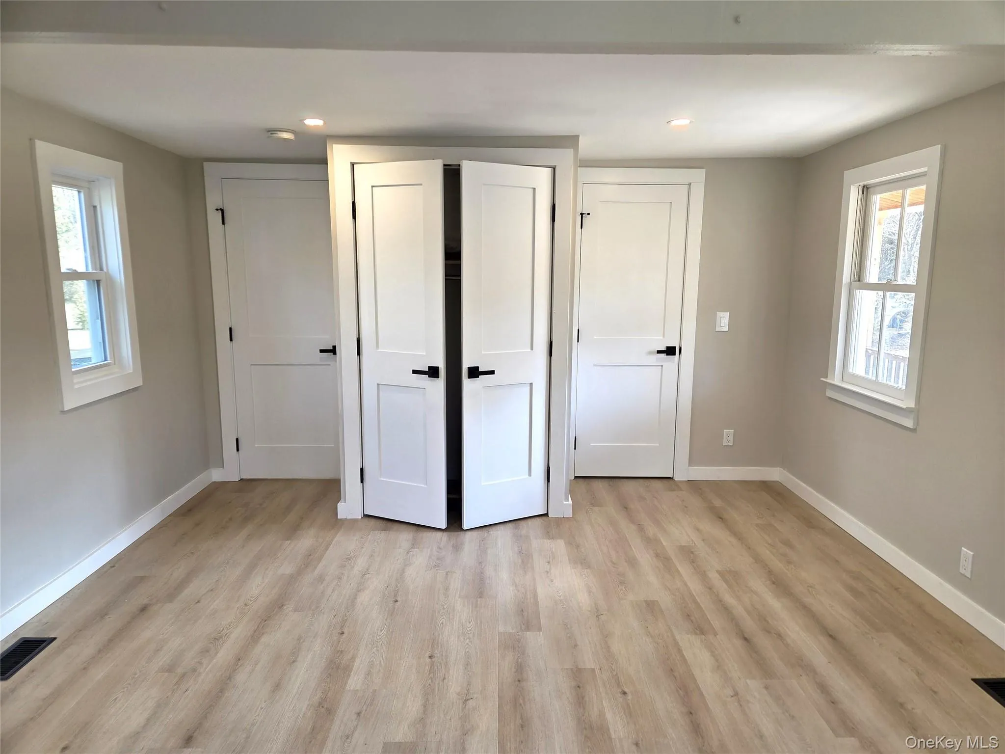 View Of The Other Side Of The Primary Bedroom Showing The Entry Door, Double Doors To One Of The Several Built In Closets, And The Doorway To The Stunning Primary Bathroom. View Of The Other Side Of The Primary Bedroom Showing The Entry Door, Double Doors To One Of The Several Built In Closets, And The Doorway To The Stunning Primary Bathroom.