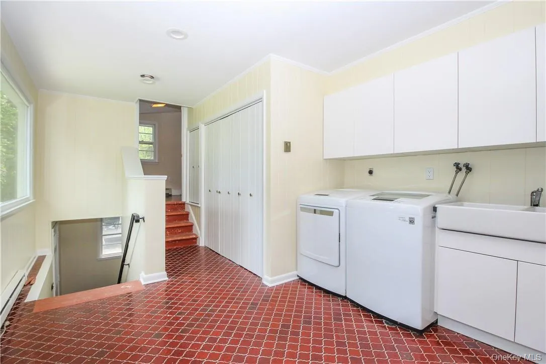 Laundry room with steps up to extra room, steps down to 2 car garage and back yard Laundry room with steps up to extra room, steps down to 2 car garage and back yard