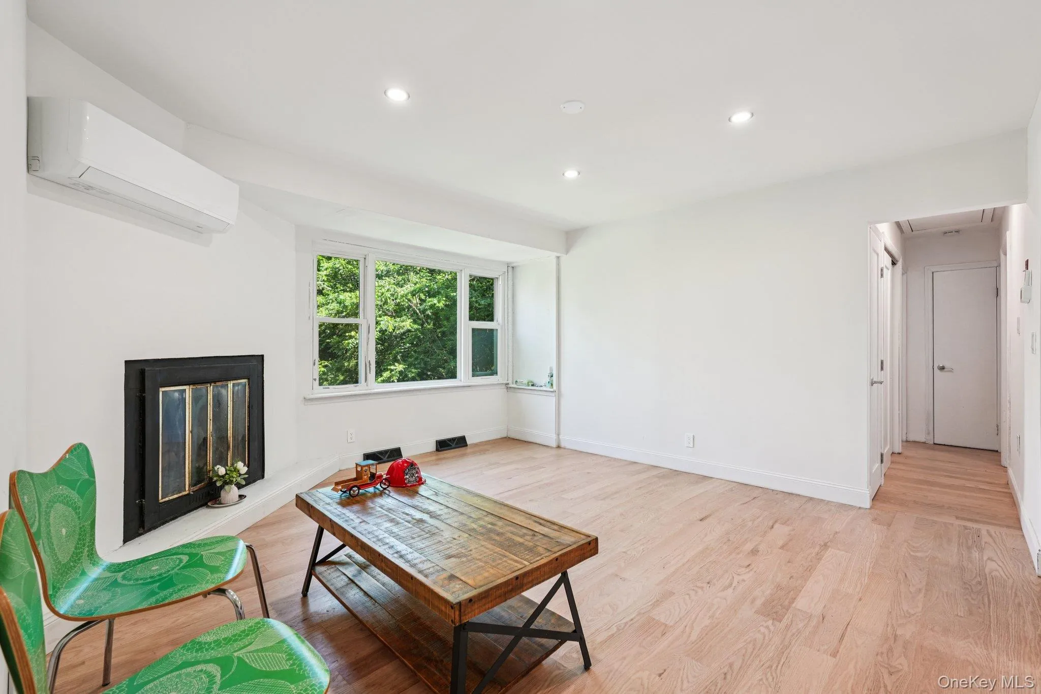 Living room, light flooring, recessed lighting, and a glass covered fireplace Living room, light flooring, recessed lighting, and a glass covered fireplace