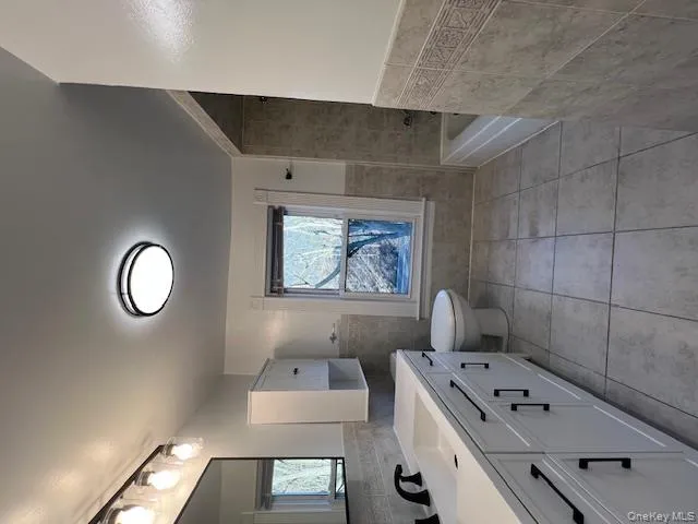 Tiled Bathroom shower/tub and new vanity, cabinets and light fixtures. Tiled Bathroom shower/tub and new vanity, cabinets and light fixtures.