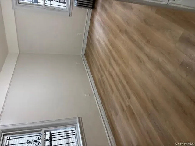 Spare room featuring wood finished floors and radiator heating unit Spare room featuring wood finished floors and radiator heating unit