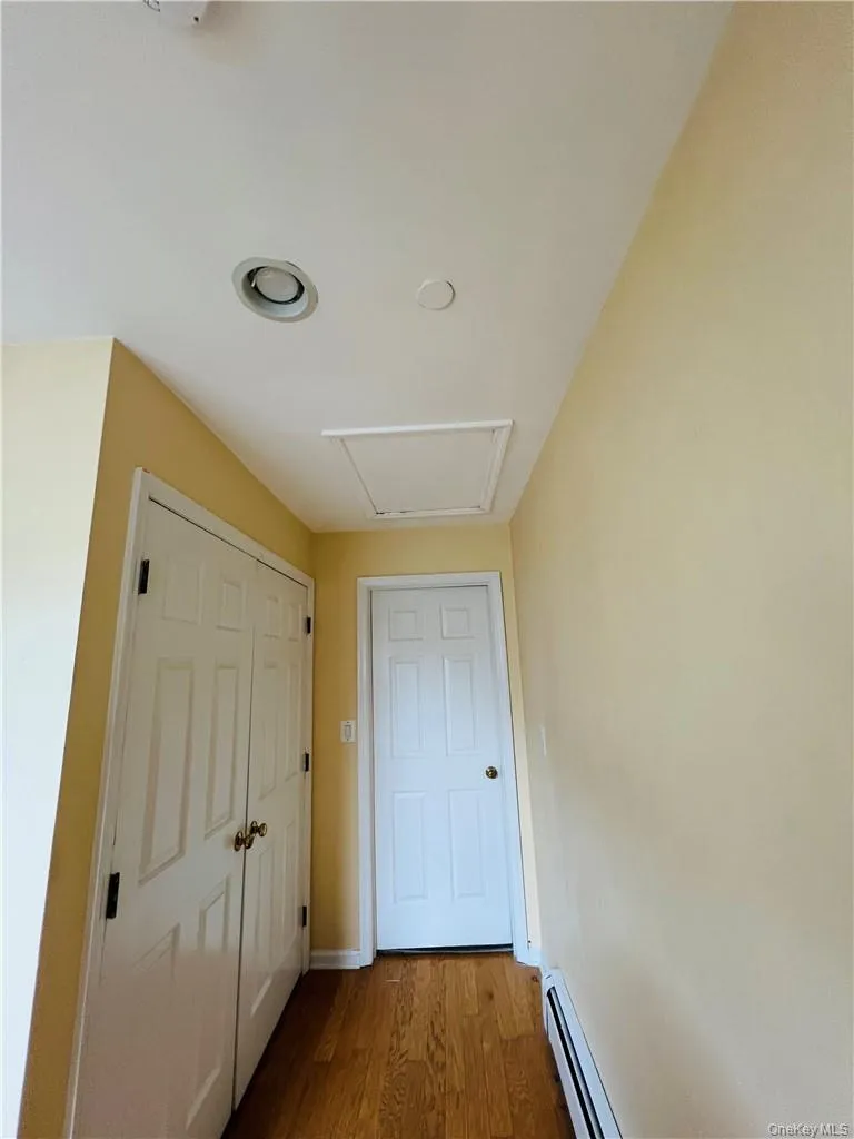 Hallway with wood-type flooring, Laundry + attic with bessler stairs Hallway with wood-type flooring, Laundry + attic with bessler stairs