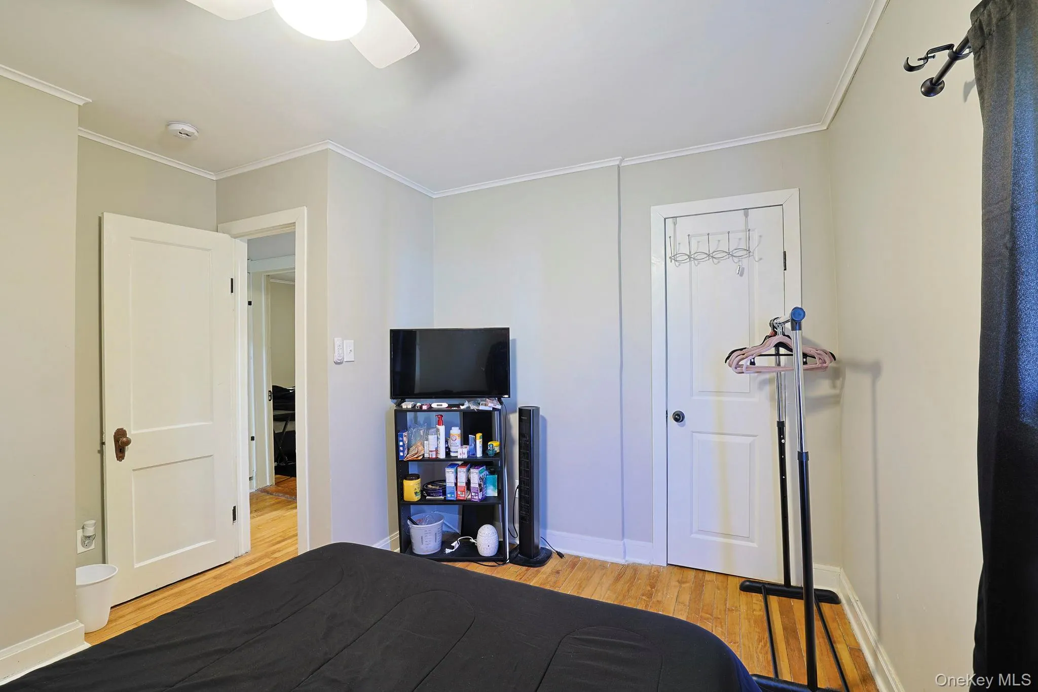 Bedroom featuring light wood-style flooring, baseboards, ceiling fan, and crown molding Bedroom featuring light wood-style flooring, baseboards, ceiling fan, and crown molding