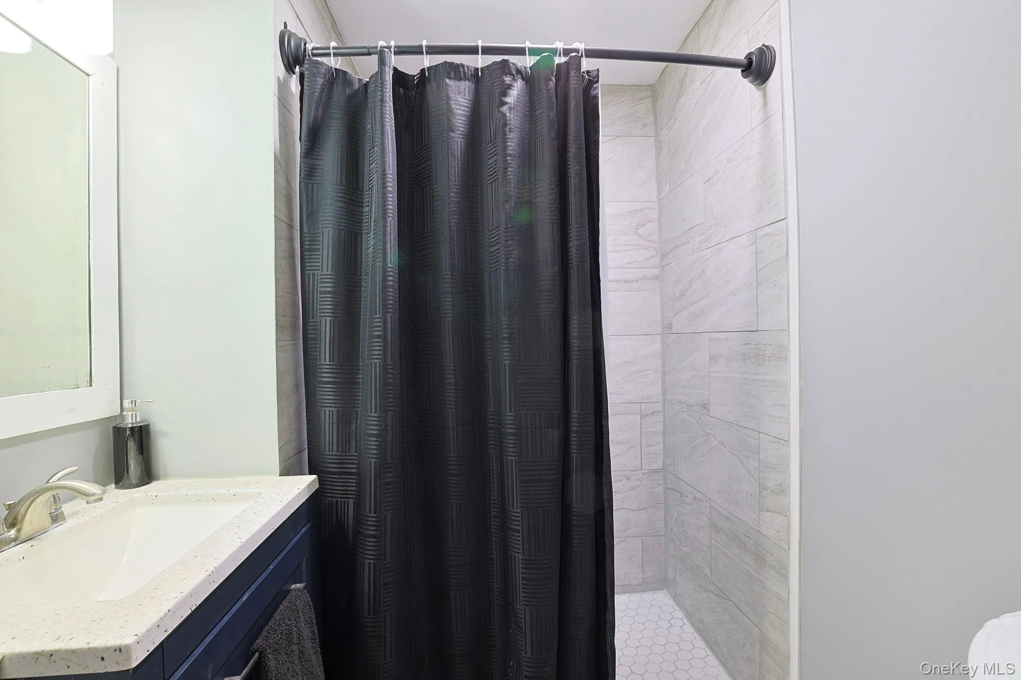 Full bath featuring a tile shower and vanity Full bath featuring a tile shower and vanity