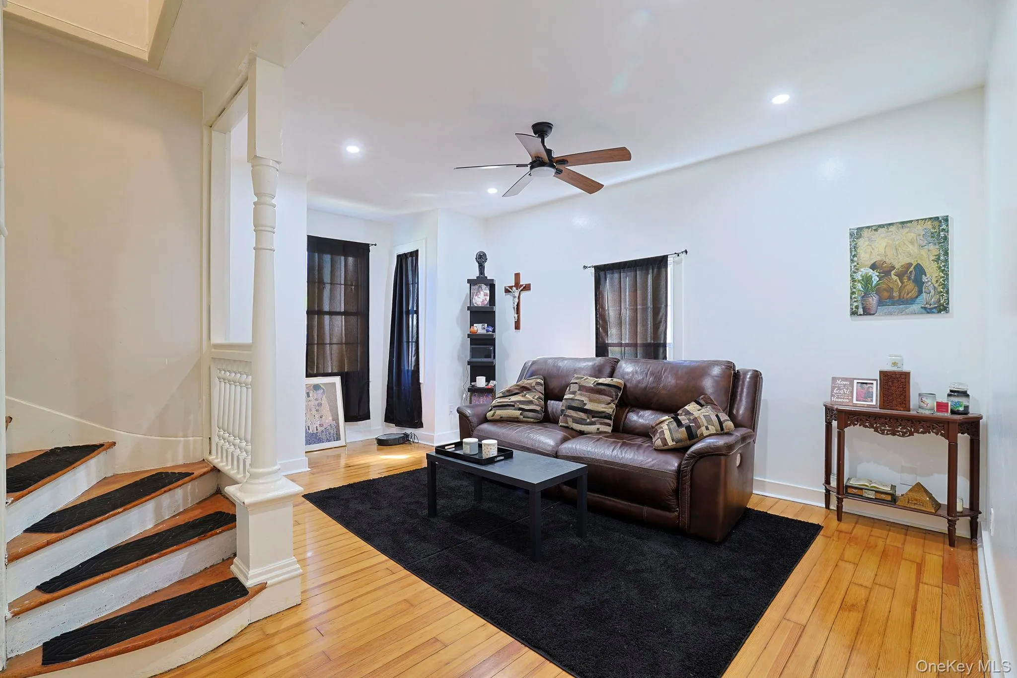 Living room featuring recessed lighting, light wood finished floors, baseboards, stairs, and ceiling fan Living room featuring recessed lighting, light wood finished floors, baseboards, stairs, and ceiling fan