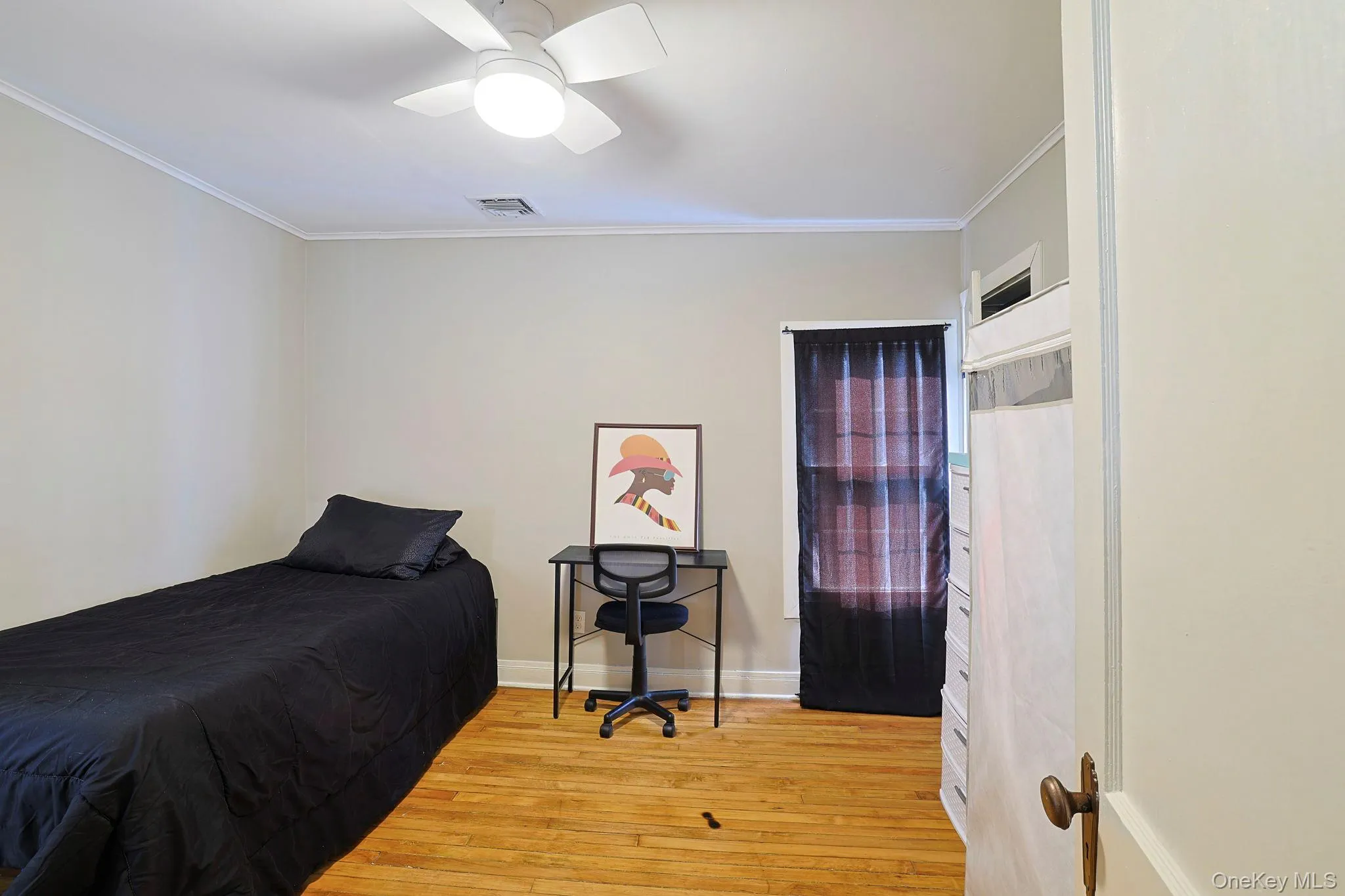 Bedroom with light wood-style flooring, visible vents, crown molding, and baseboards Bedroom with light wood-style flooring, visible vents, crown molding, and baseboards