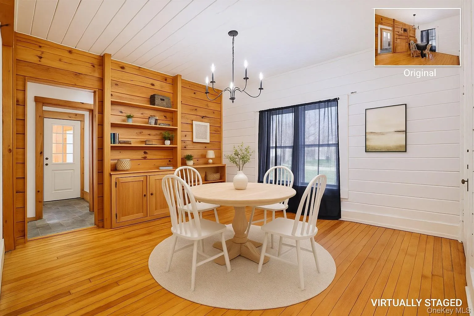 Dining room featuring light wood-type flooring, wood walls, a chandelier, and baseboards Dining room featuring light wood-type flooring, wood walls, a chandelier, and baseboards