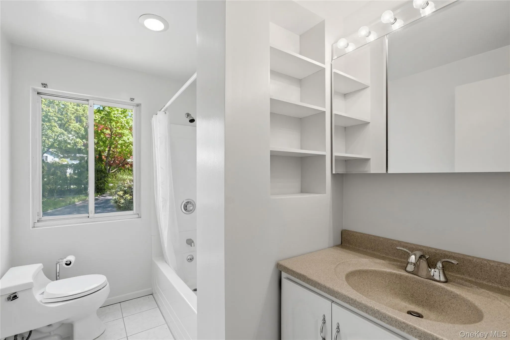 Bathroom featuring a built-in vanity with integrated sink, chrome fixtures, and tub Bathroom featuring a built-in vanity with integrated sink, chrome fixtures, and tub