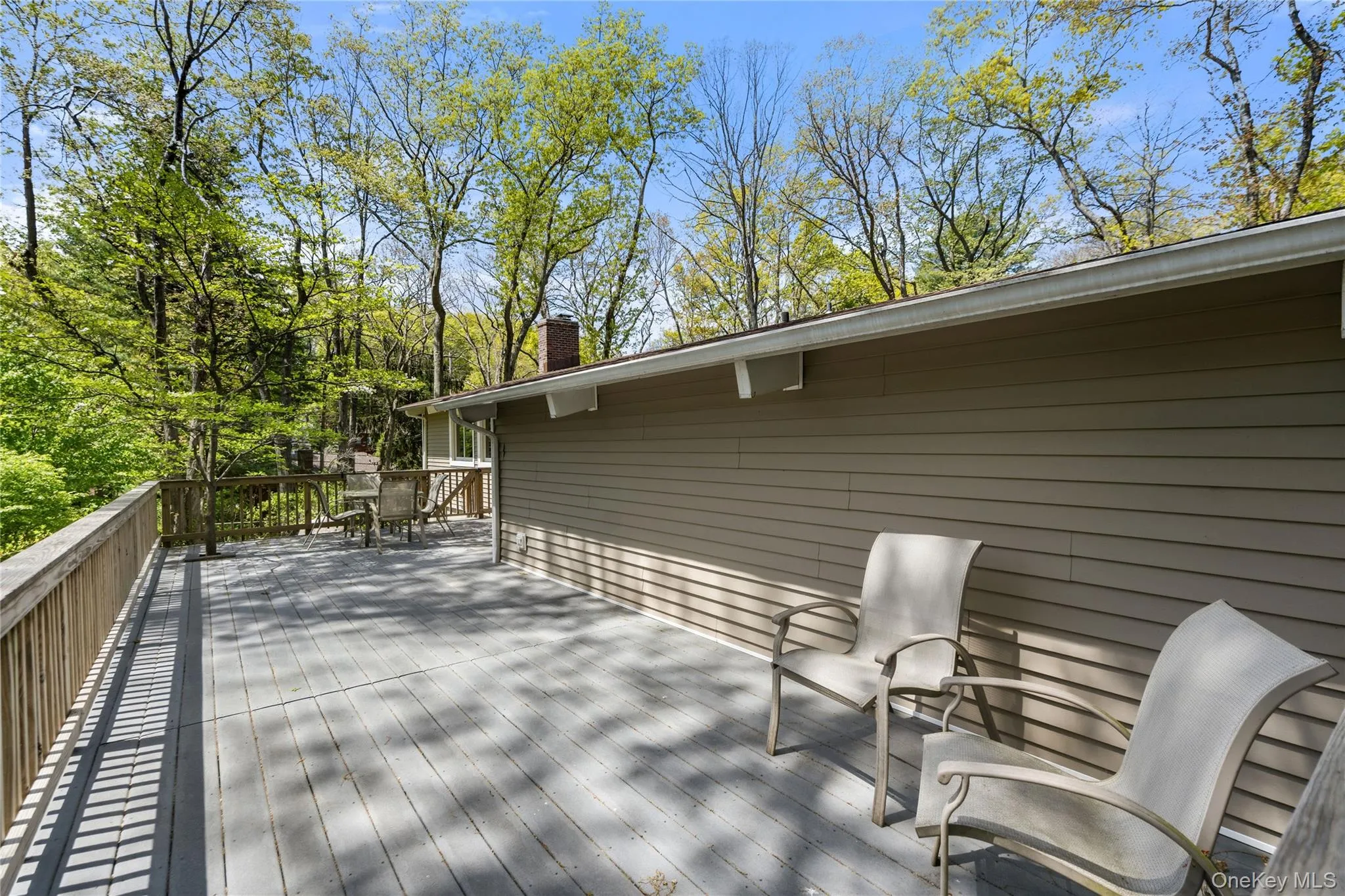 Expansive deck with railing, offering a substantial outdoor living area Expansive deck with railing, offering a substantial outdoor living area