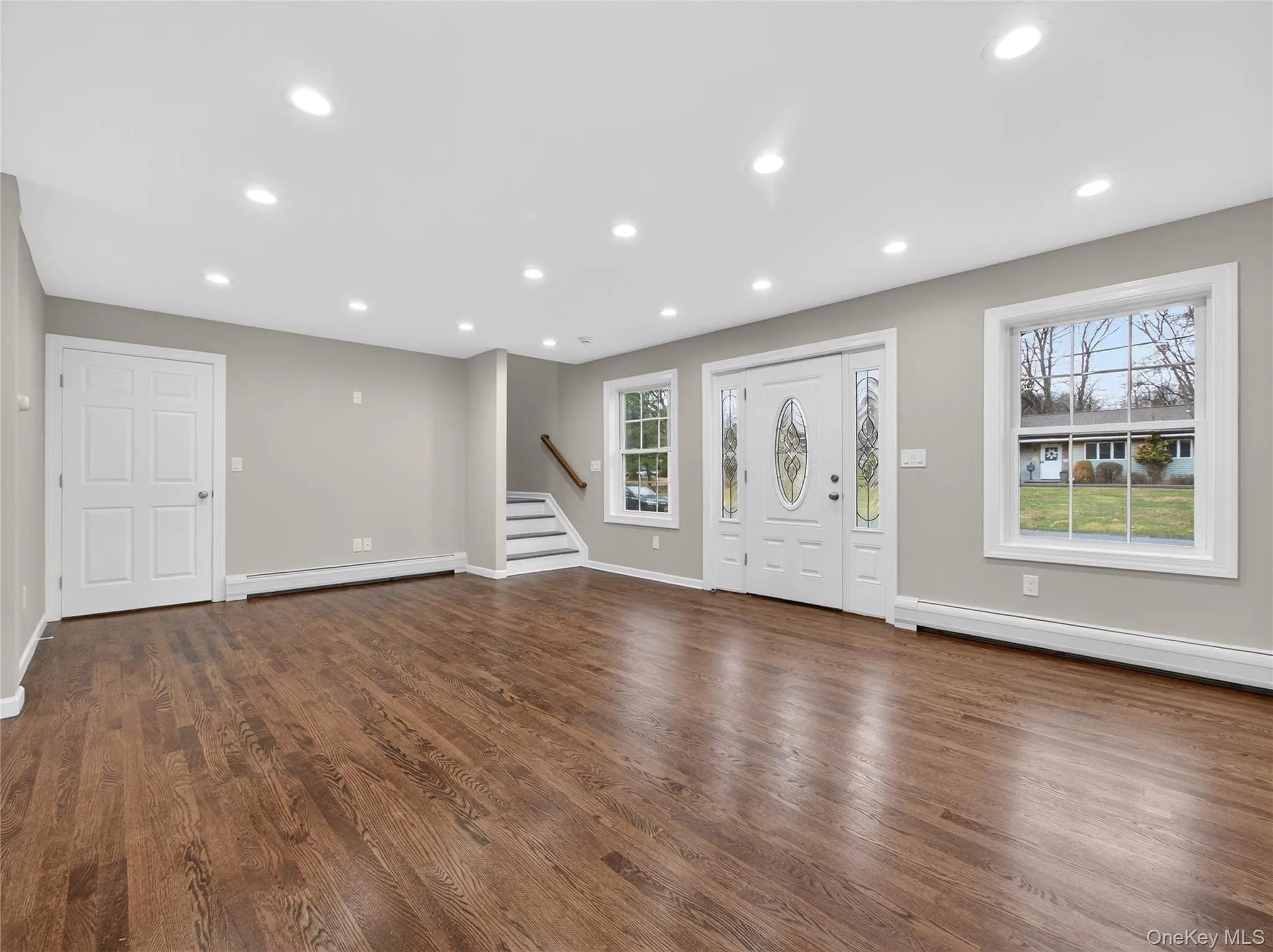 Entryway featuring recessed lighting, dark wood-type flooring, and a baseboard radiator Entryway featuring recessed lighting, dark wood-type flooring, and a baseboard radiator