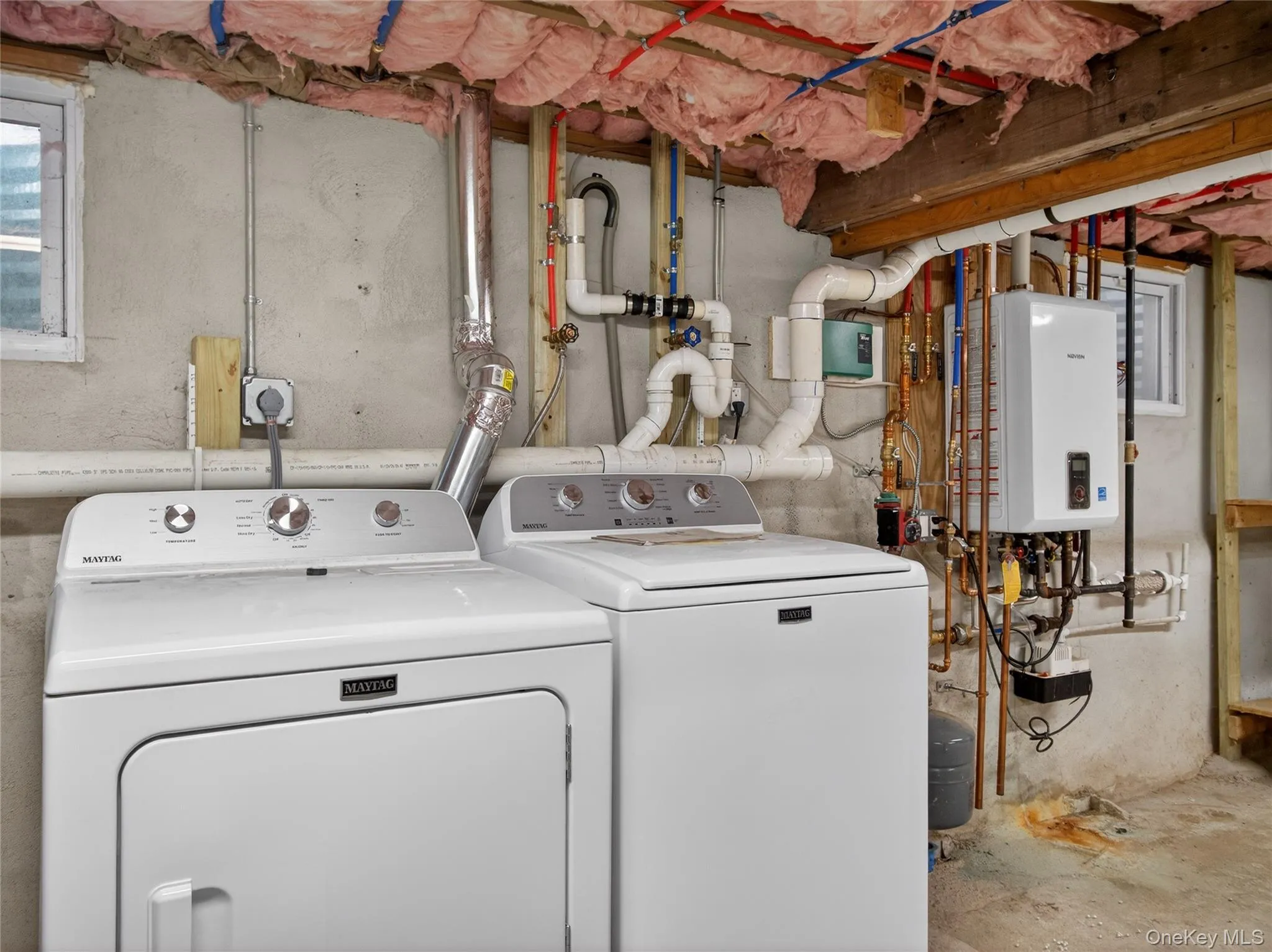 Laundry area with water heater, independent washer and dryer, and concrete flooring Laundry area with water heater, independent washer and dryer, and concrete flooring