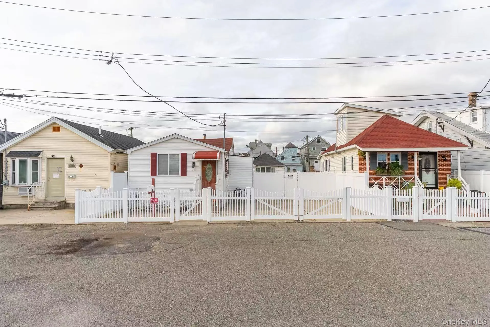 Bungalow-style home featuring a fenced front yard, a residential view, and a gate Bungalow-style home featuring a fenced front yard, a residential view, and a gate