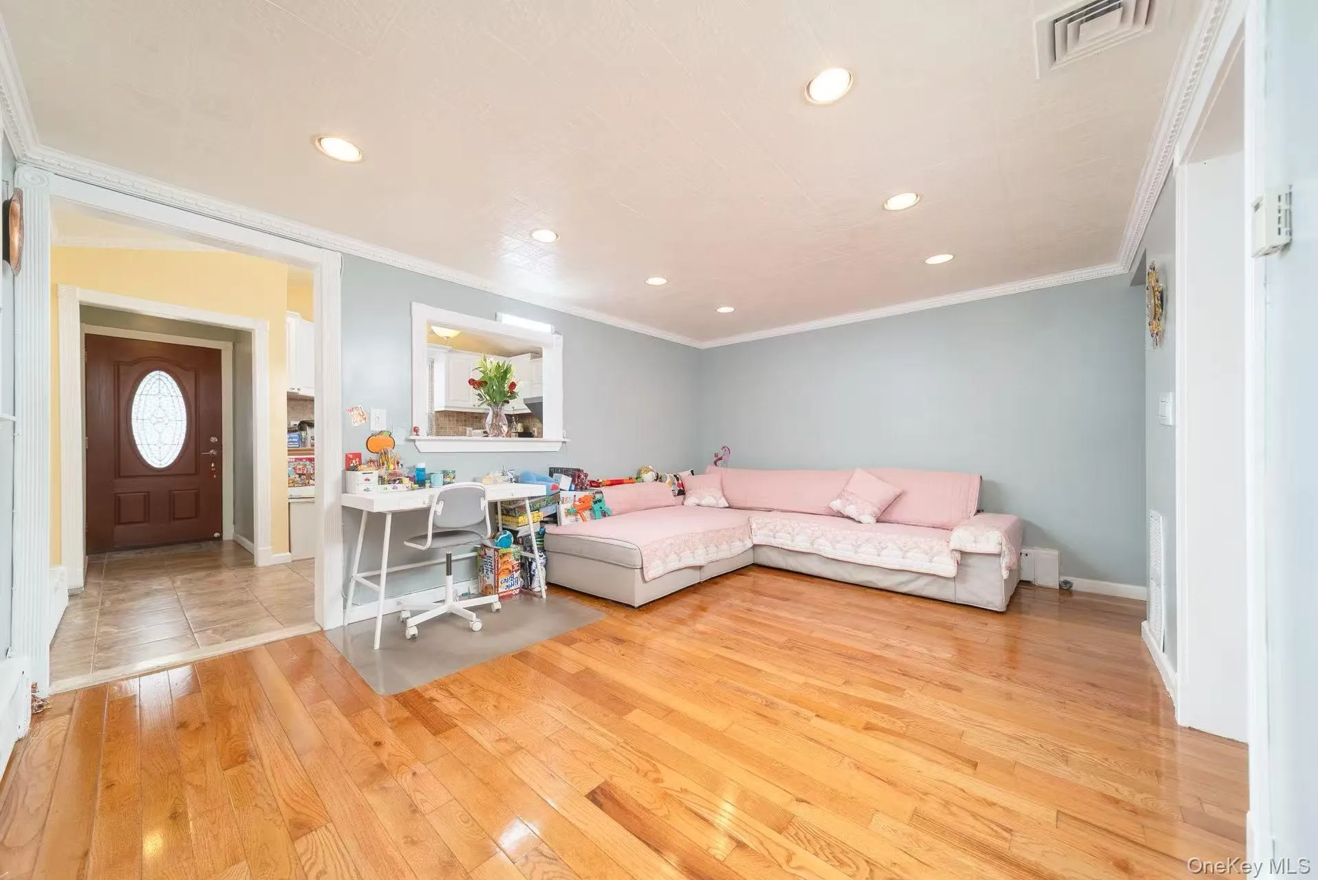 Living room with crown molding, light wood-style floors, and recessed lighting Living room with crown molding, light wood-style floors, and recessed lighting