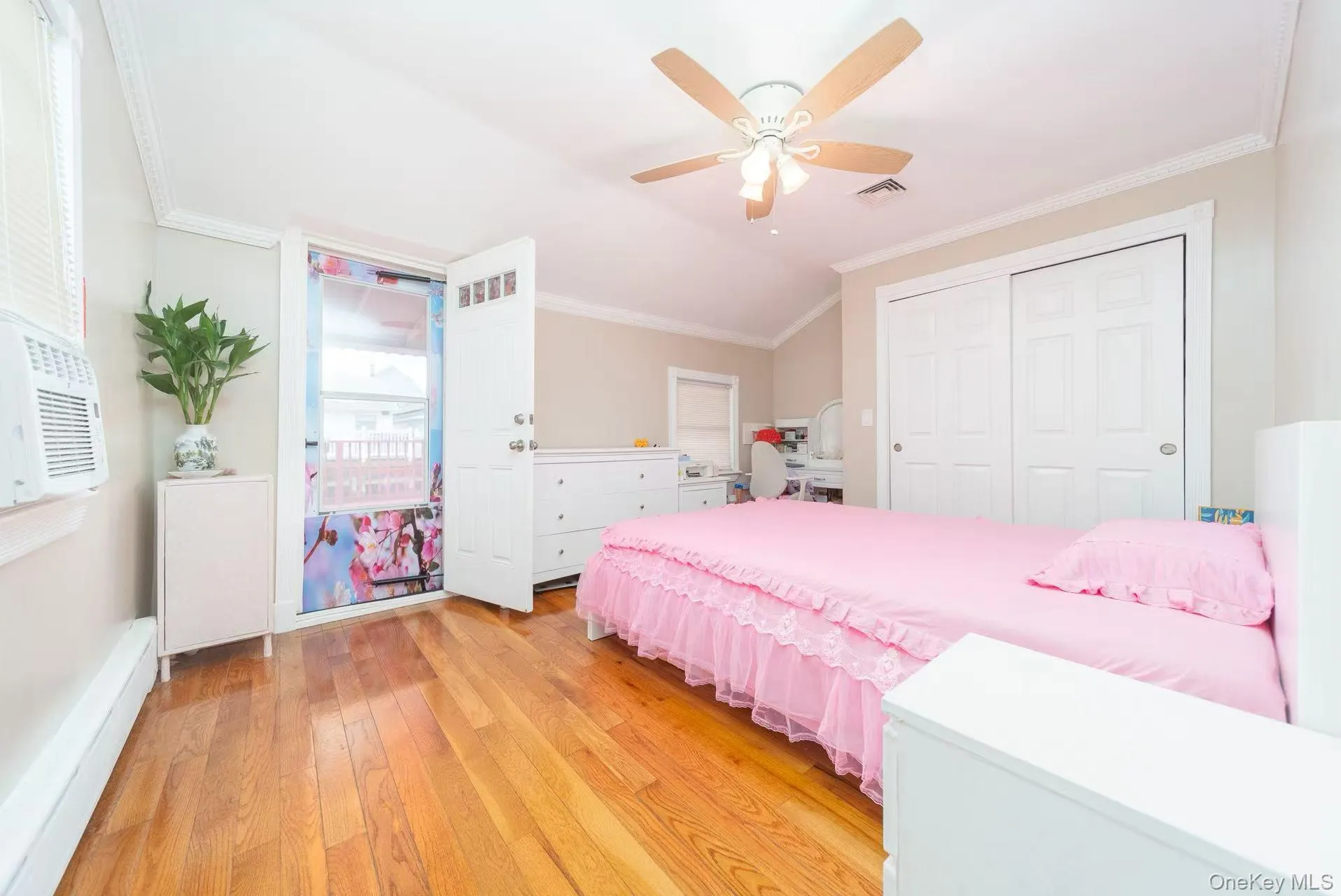 Bedroom with crown molding, light wood-style floors, a ceiling fan, a closet, and cooling unit Bedroom with crown molding, light wood-style floors, a ceiling fan, a closet, and cooling unit