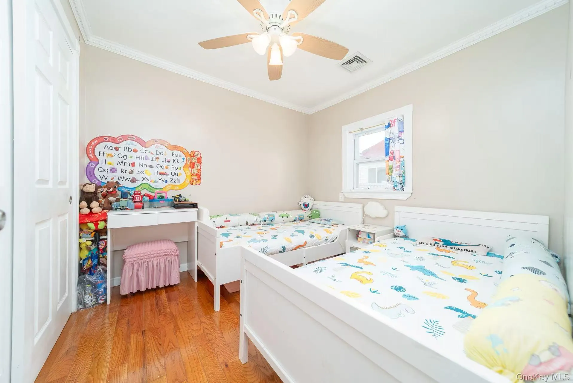 Bedroom featuring ornamental molding, light wood-style floors, and ceiling fan Bedroom featuring ornamental molding, light wood-style floors, and ceiling fan