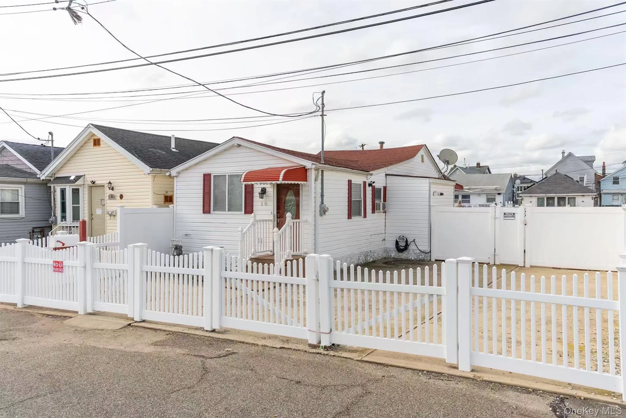 View of front of house with a gate, a fenced front yard, and a residential view View of front of house with a gate, a fenced front yard, and a residential view