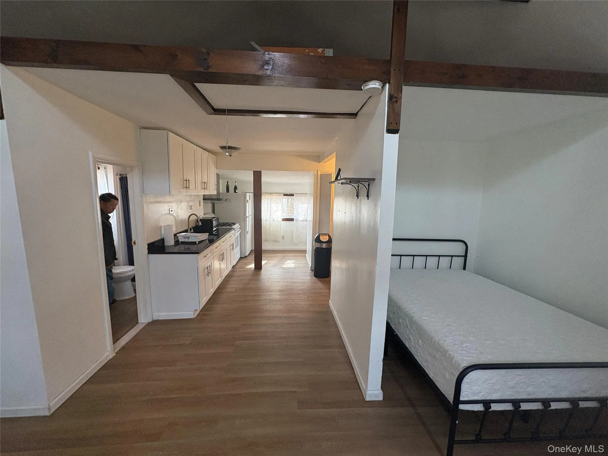 Open-concept living space with sleeping area and kitchen flow Open-concept living space with sleeping area and kitchen flow