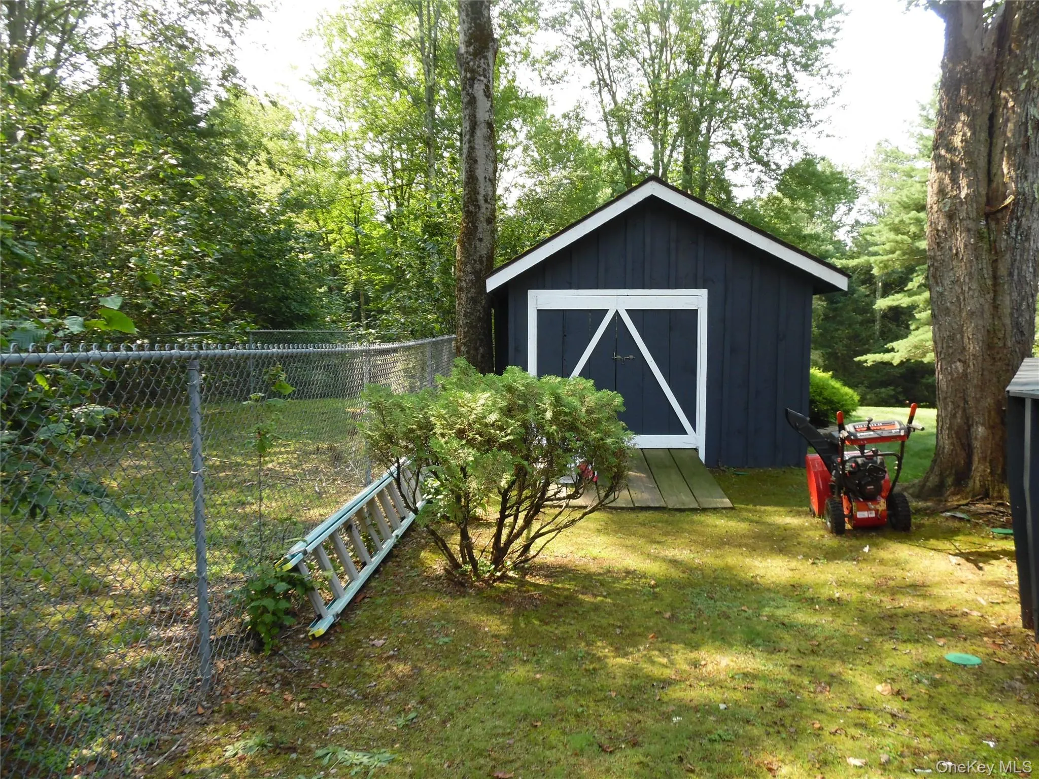 Detached shed with white trim and a gabled roof Detached shed with white trim and a gabled roof