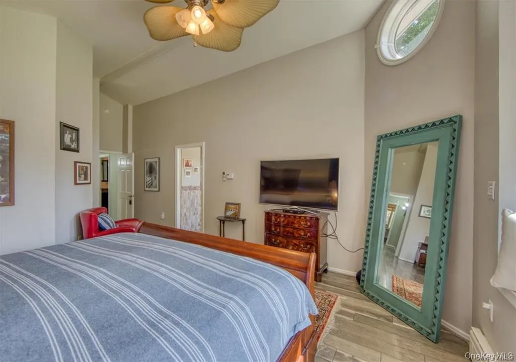 Vaulted ceiling with a ceiling fan, wood-finish flooring, and an oval window Vaulted ceiling with a ceiling fan, wood-finish flooring, and an oval window