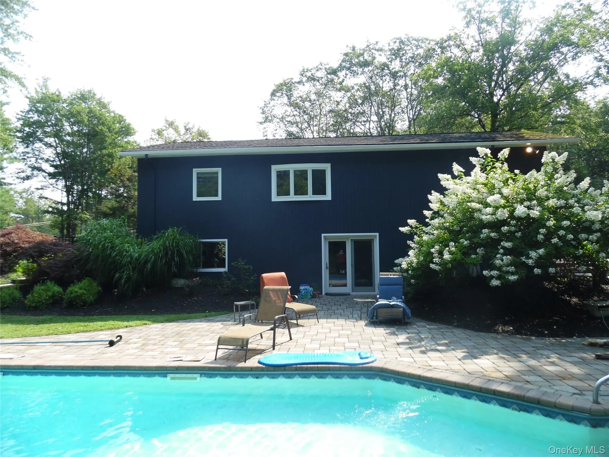 In-ground swimming pool with a paver patio and ample landscaping In-ground swimming pool with a paver patio and ample landscaping