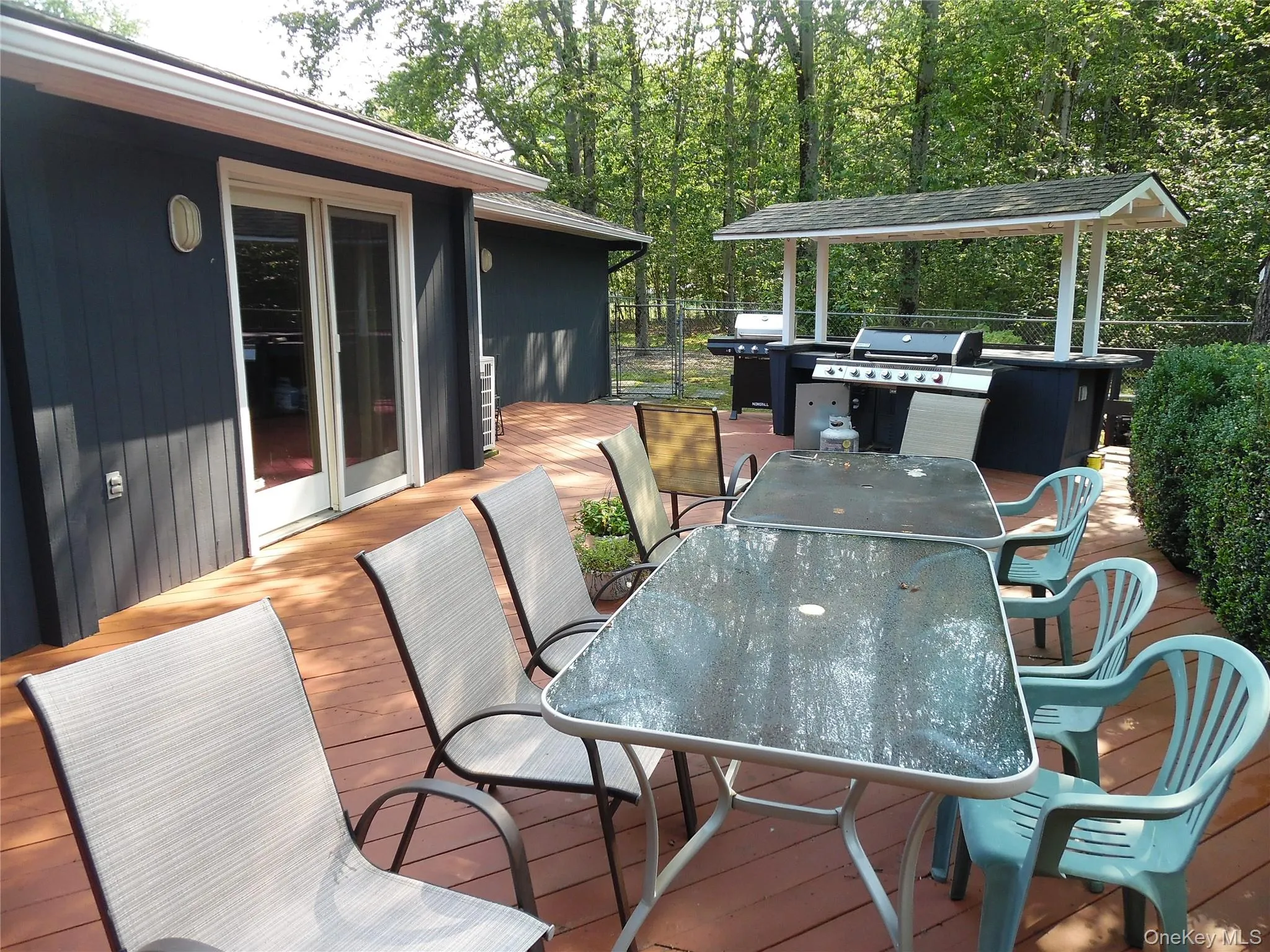 Expansive wood-finish deck with a built-in outdoor kitchen and sliding glass doors Expansive wood-finish deck with a built-in outdoor kitchen and sliding glass doors