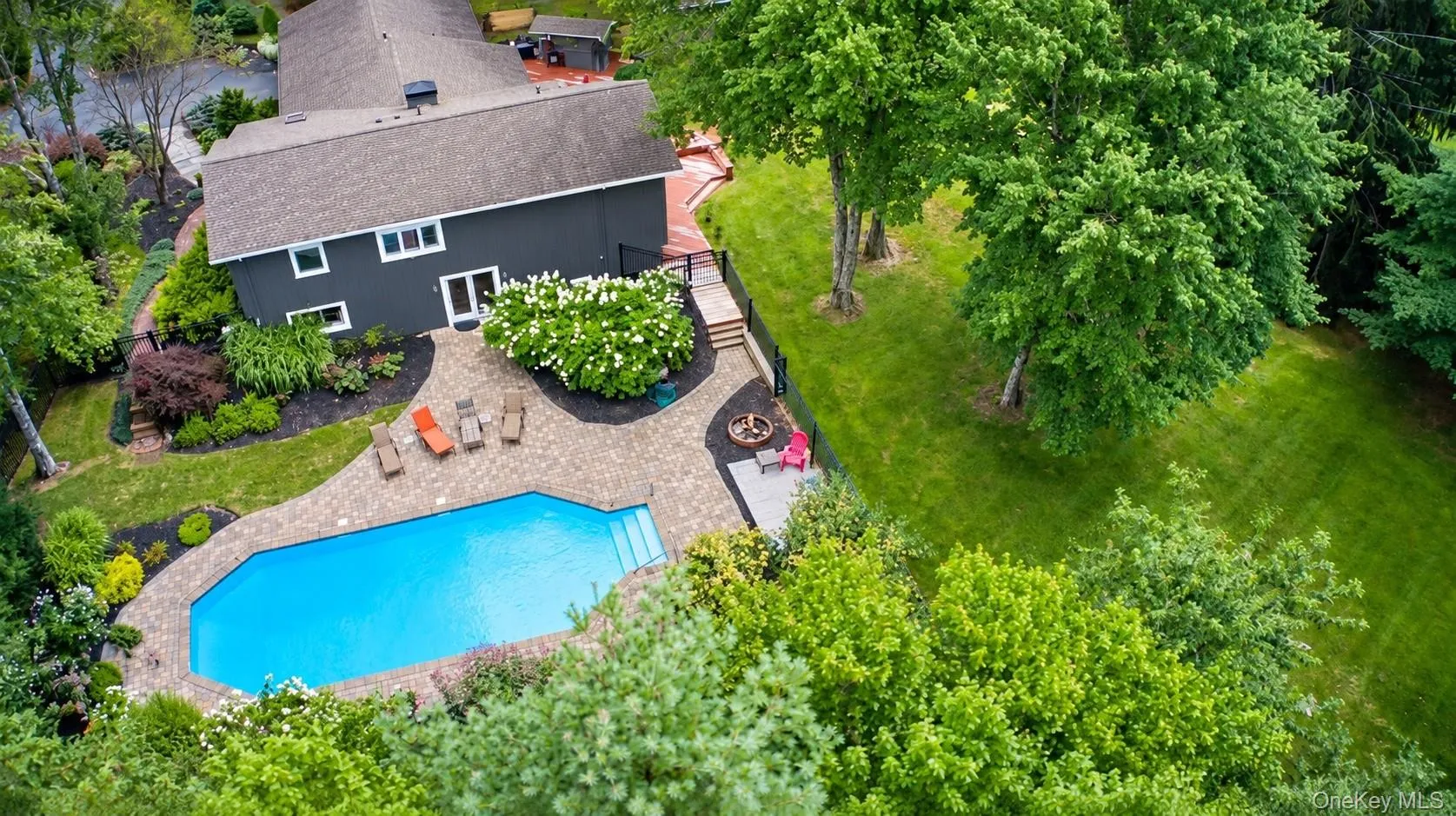 Outdoor swimming pool with integrated steps, surrounded by a paver patio Outdoor swimming pool with integrated steps, surrounded by a paver patio