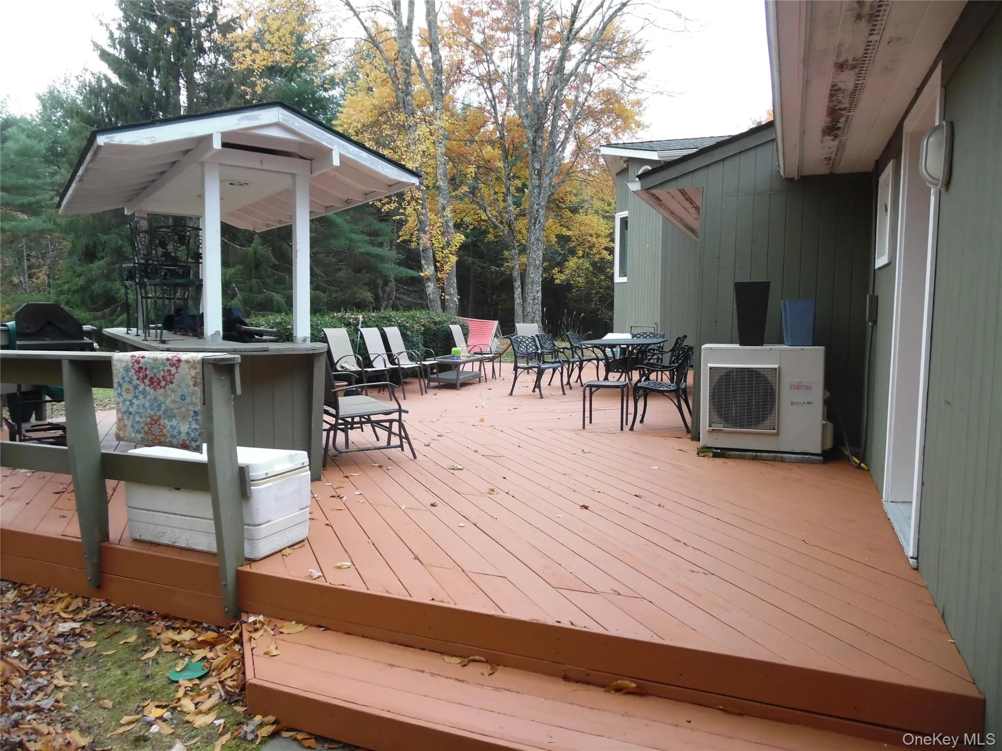 Wooden deck with outdoor dining area and a grill Wooden deck with outdoor dining area and a grill