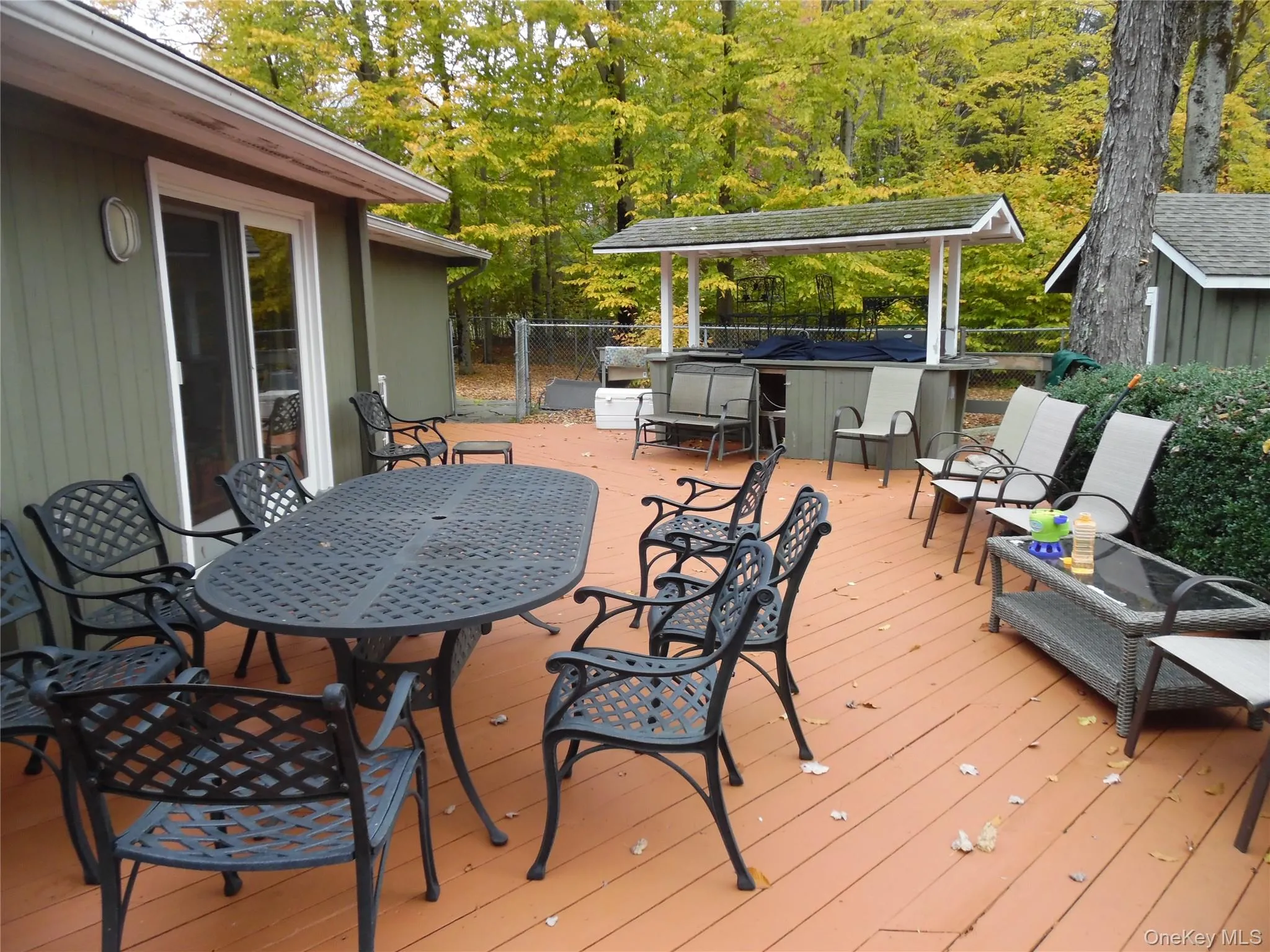 Wooden deck featuring an outdoor bar and dining area and an outdoor structure Wooden deck featuring an outdoor bar and dining area and an outdoor structure