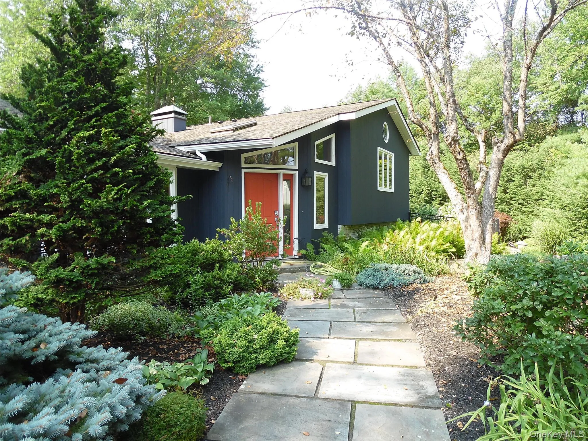 Dark-toned exterior with a prominent red entry door Dark-toned exterior with a prominent red entry door