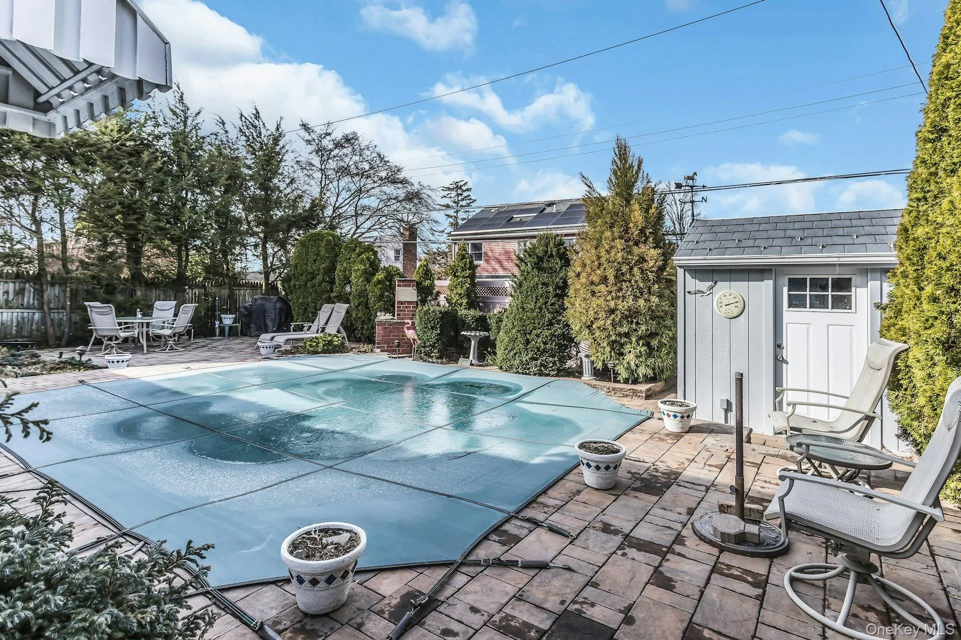 View of pool featuring patio surround, a storage unit, and a fenced backyard View of pool featuring patio surround, a storage unit, and a fenced backyard