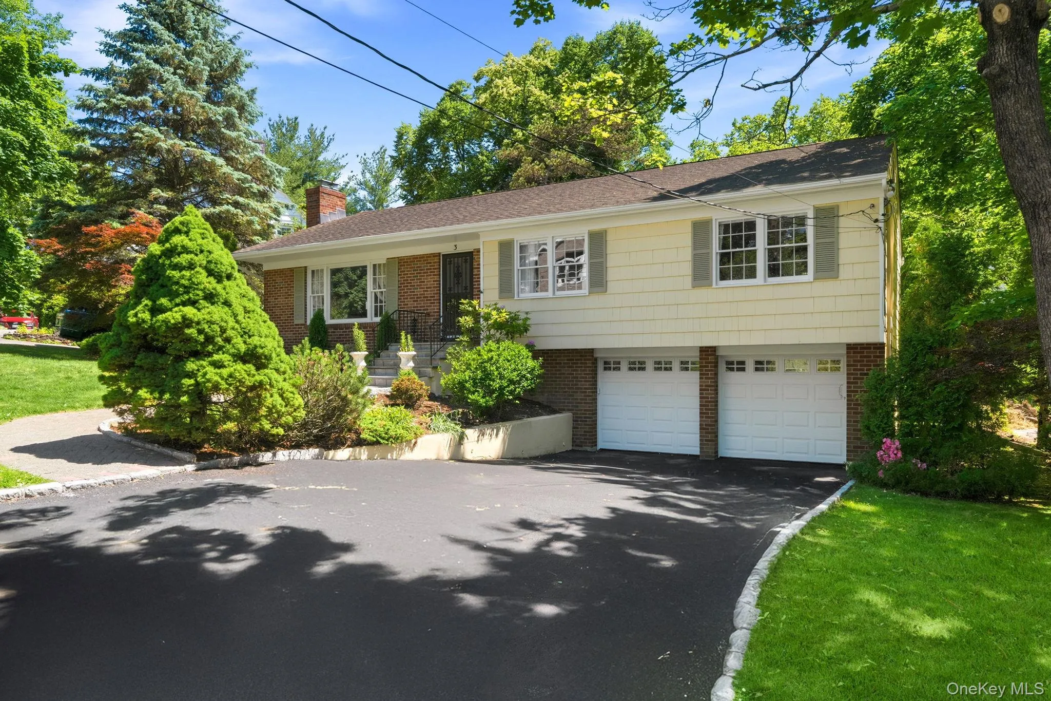Expansive driveway and oversized two-car garage ready for cars, hobbies, and storage. Expansive driveway and oversized two-car garage ready for cars, hobbies, and storage.
