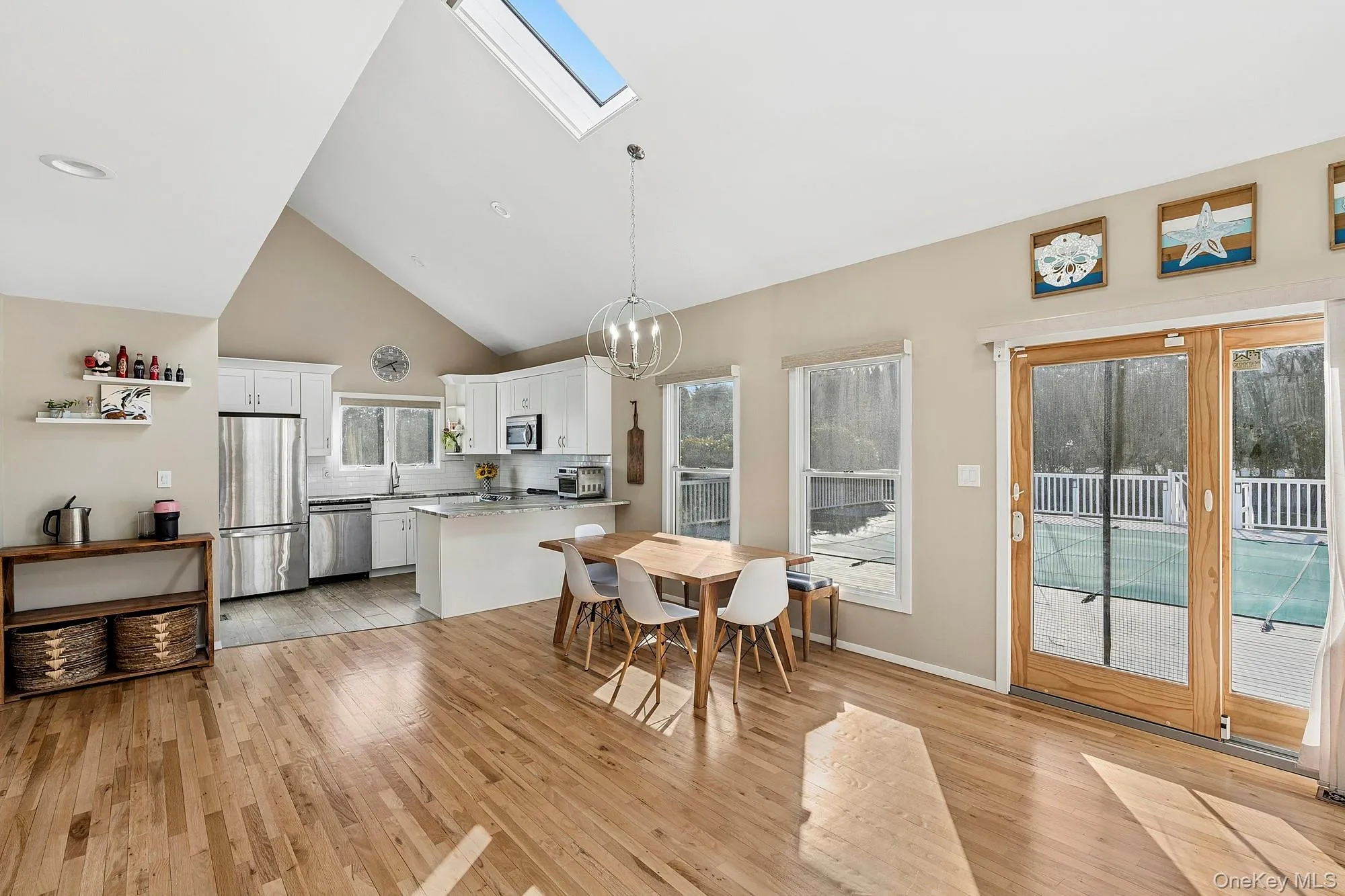 Post-modern home featuring an open living room with fireplace, glass sliders to the inground pool, and an open eat-in kitchen. Post-modern home featuring an open living room with fireplace, glass sliders to the inground pool, and an open eat-in kitchen.