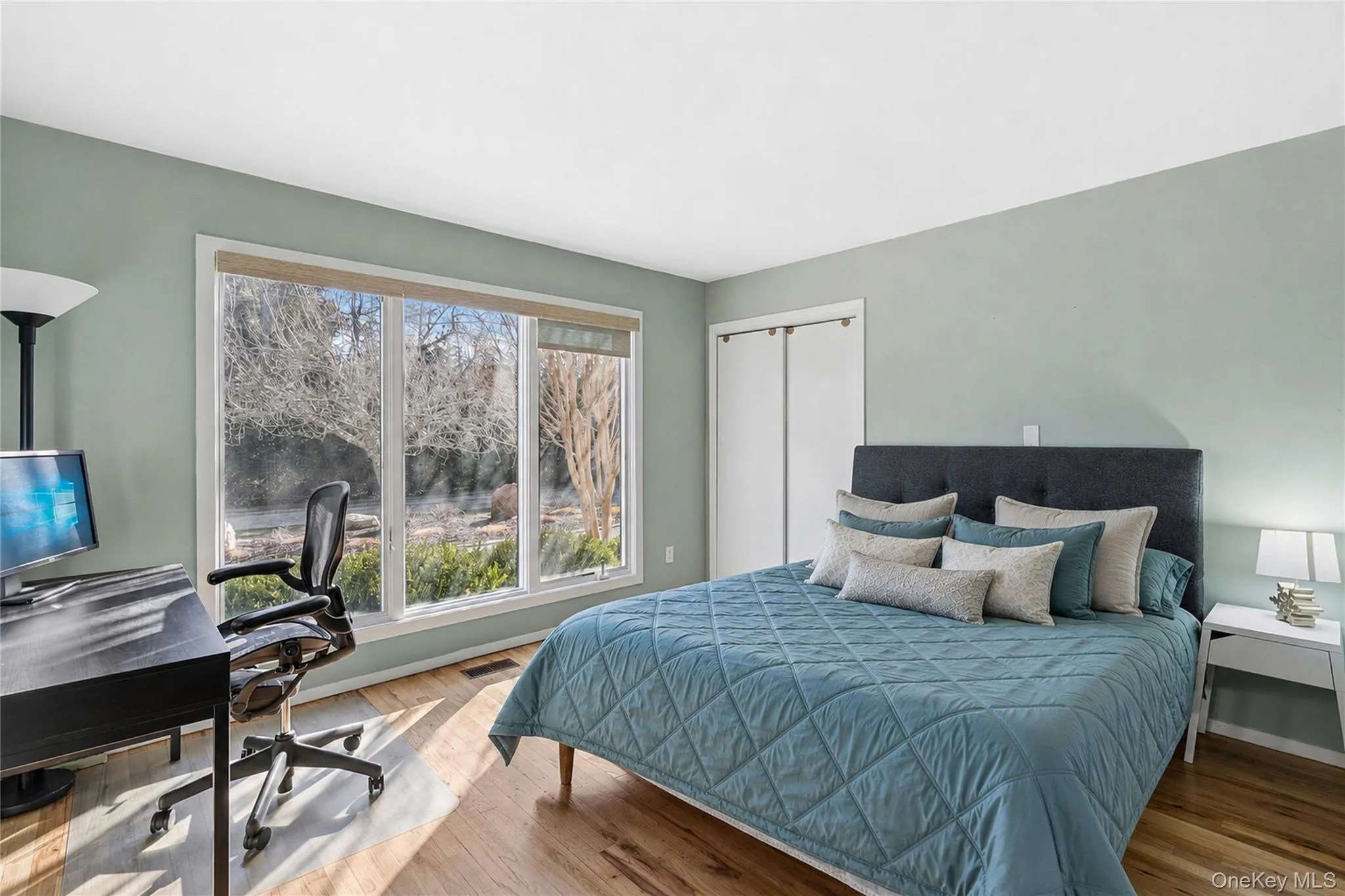 Convenient first-floor bedroom featuring generous closet space, abundant natural light, and oversized modern windows. Convenient first-floor bedroom featuring generous closet space, abundant natural light, and oversized modern windows.