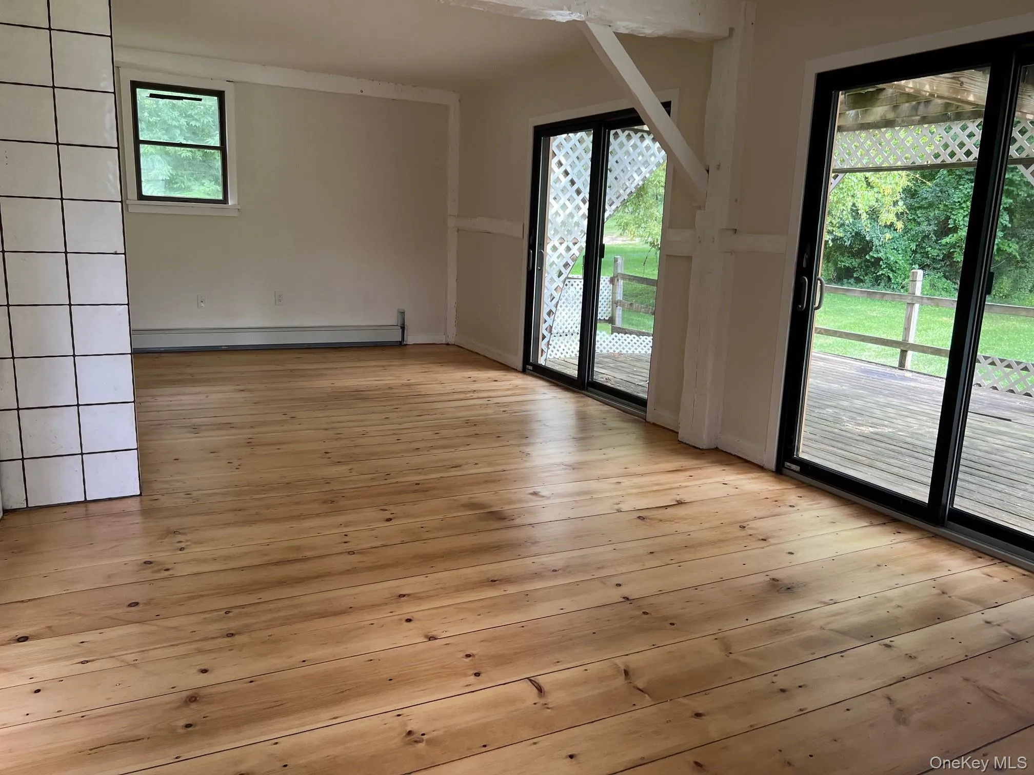 Unfurnished room with light wood-style flooring and a baseboard radiator Unfurnished room with light wood-style flooring and a baseboard radiator