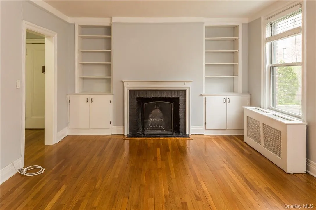 Living Room featuring fireplace, built-in shelving and hardwood floors. Living Room featuring fireplace, built-in shelving and hardwood floors.