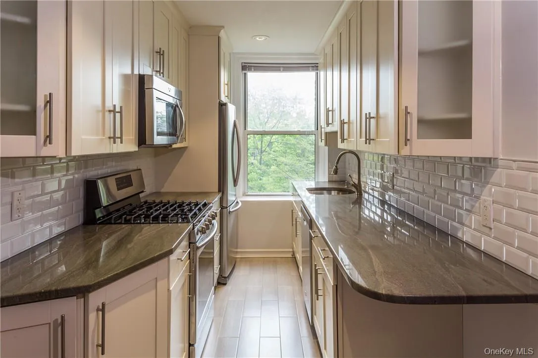 View of the Kitchen featuring granite countertops, stainless steel appliances and tile backsplash. View of the Kitchen featuring granite countertops, stainless steel appliances and tile backsplash.