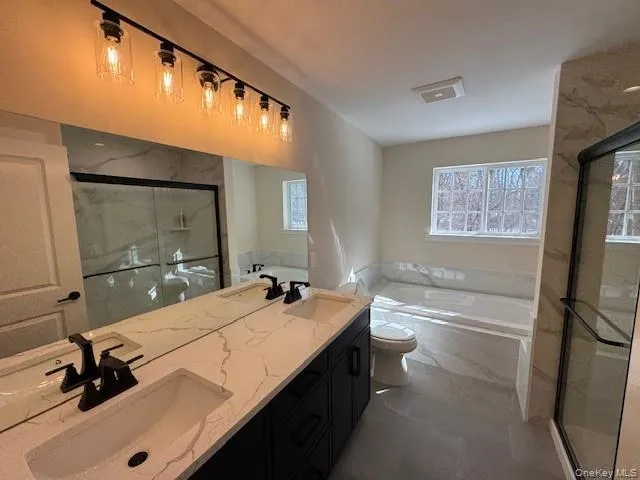 Bathroom with a garden tub, double vanity, a marble finish with separate shower, and plenty of natural light Bathroom with a garden tub, double vanity, a marble finish with separate shower, and plenty of natural light