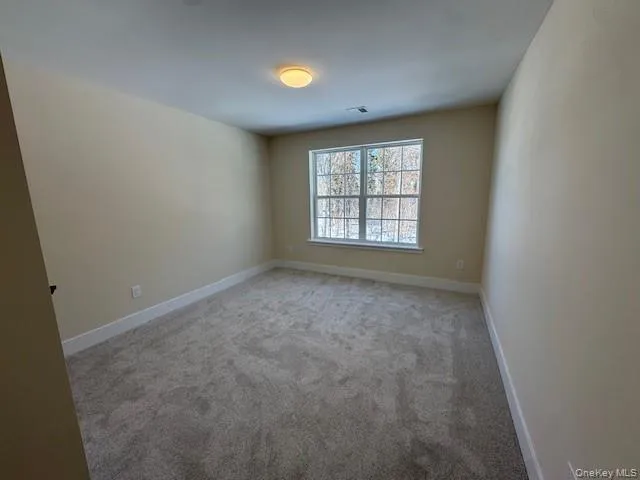 Unfurnished room featuring gray colored carpet Unfurnished room featuring gray colored carpet