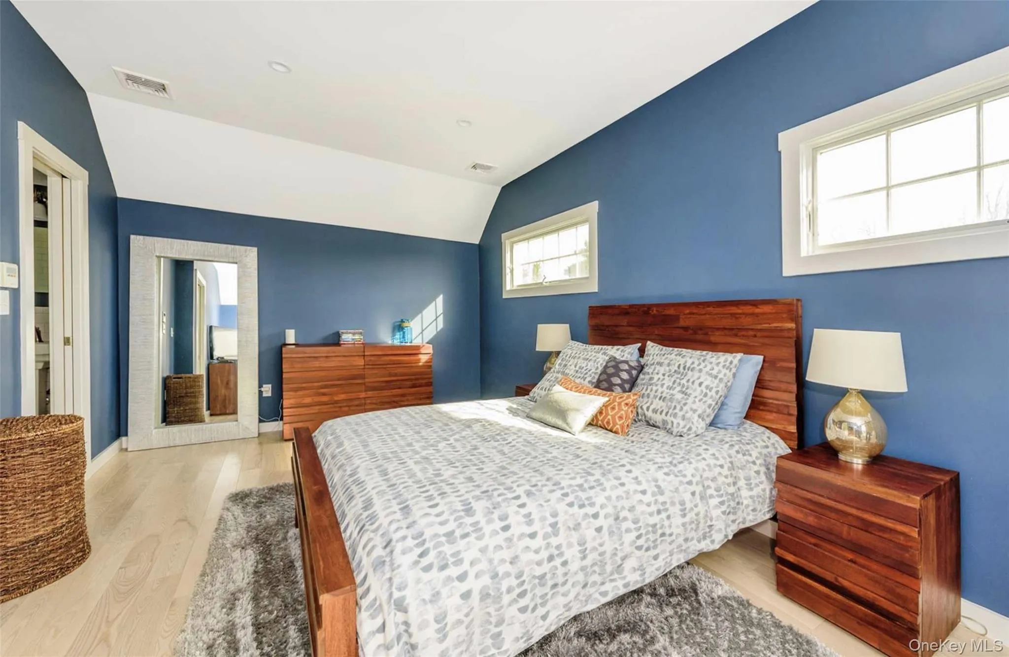 Bedroom with light hardwood / wood-style floors and lofted ceiling Bedroom with light hardwood / wood-style floors and lofted ceiling