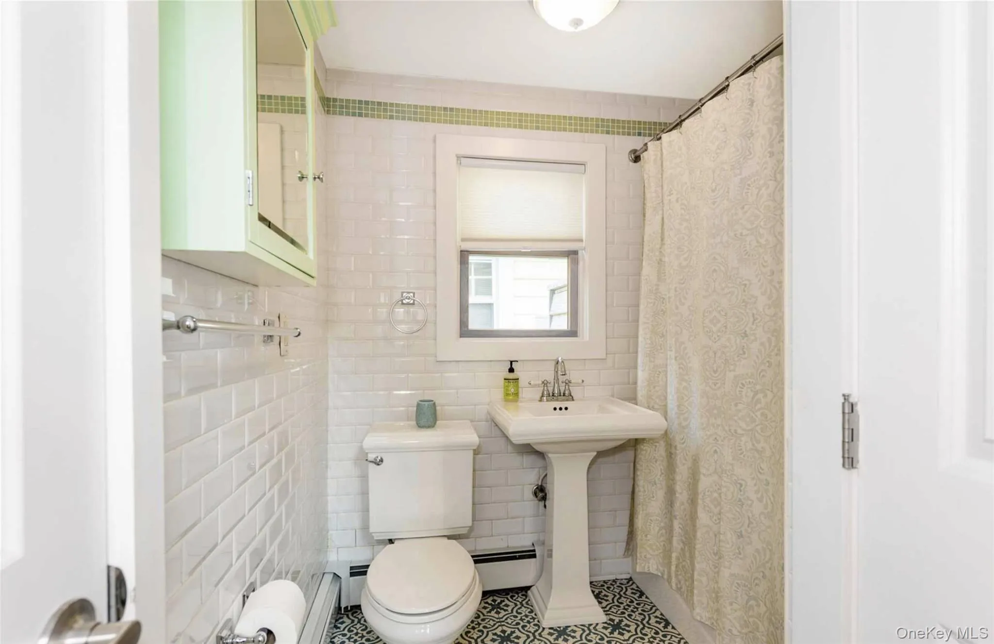 Bathroom with tile patterned flooring, toilet, tile walls, and a baseboard heating unit Bathroom with tile patterned flooring, toilet, tile walls, and a baseboard heating unit