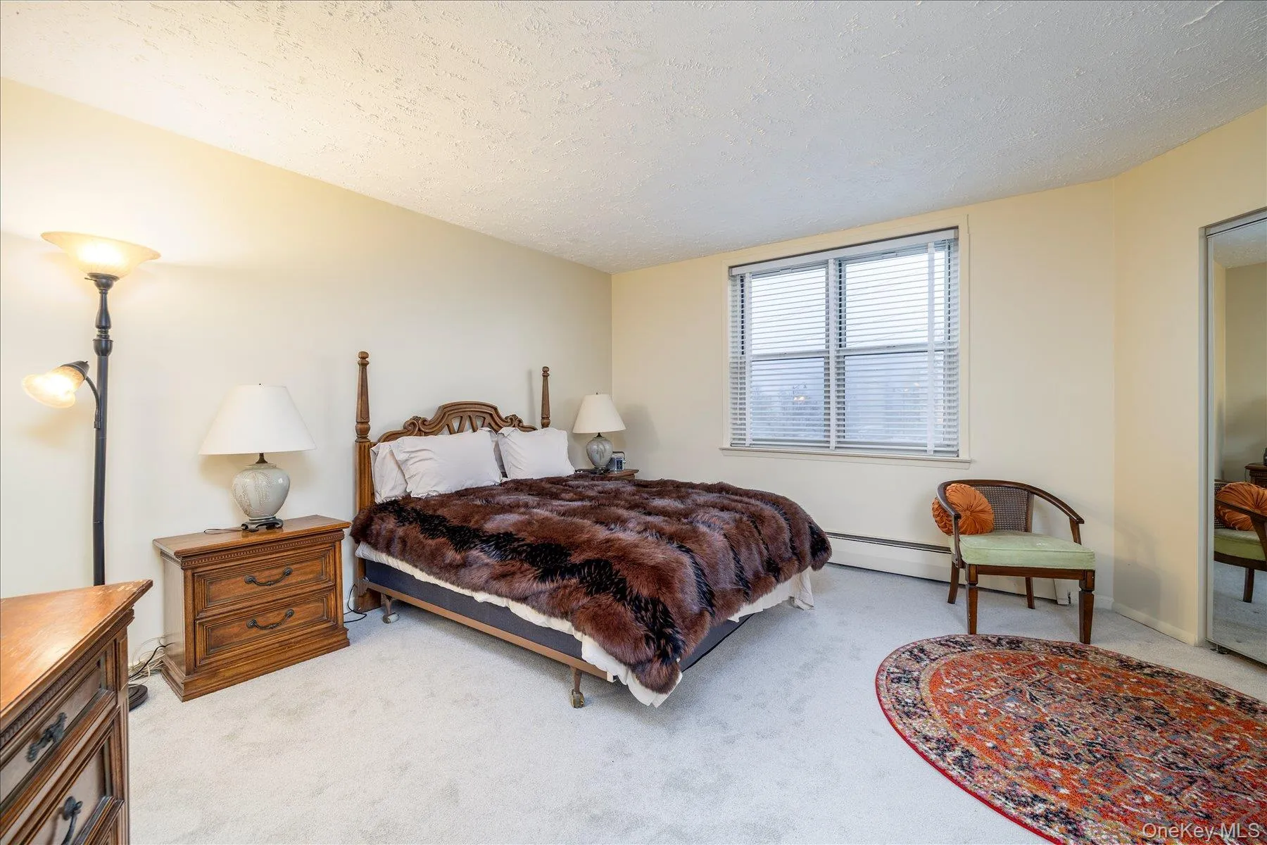 Bedroom with light carpet and a baseboard heating unit Bedroom with light carpet and a baseboard heating unit