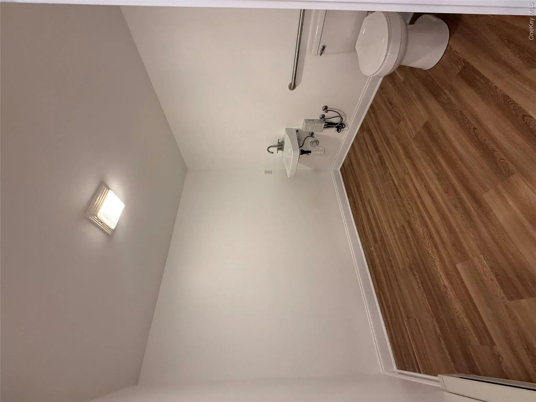 Bathroom with dark wood-style flooring and a baseboard heating unit Bathroom with dark wood-style flooring and a baseboard heating unit